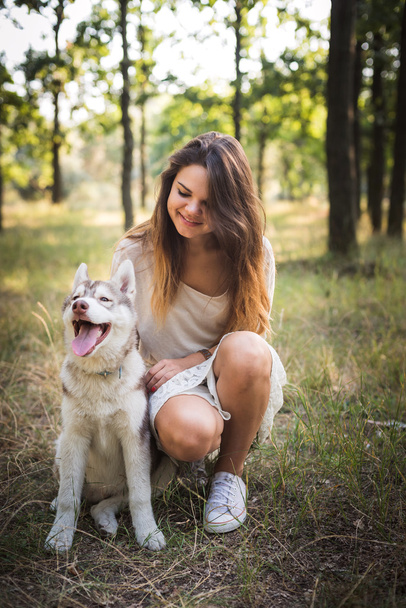 young caucasian female with siberian husky puppy in park - Foto, imagen
