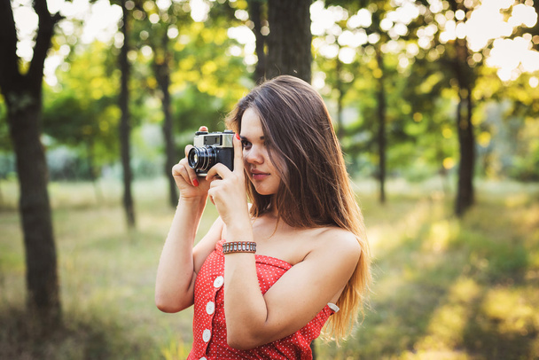 young caucasian female with vintage camera in park - Fotó, kép