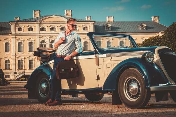 чоловік з портфелем біля класичного кабріолета
 - Фото, зображення