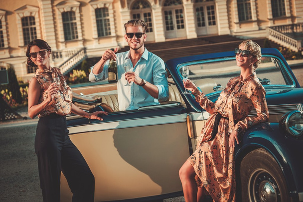 Klasik Cabrio yakınındaki şampanya içiyor arkadaşlar - Fotoğraf, Görsel