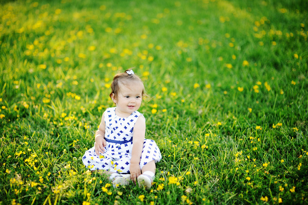 Little girl in white dress sitting on the grass - Fotografie, Obrázek