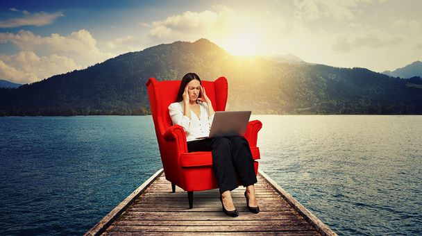 Frau sitzt auf rotem Stuhl auf Holzmoor - Foto, Bild