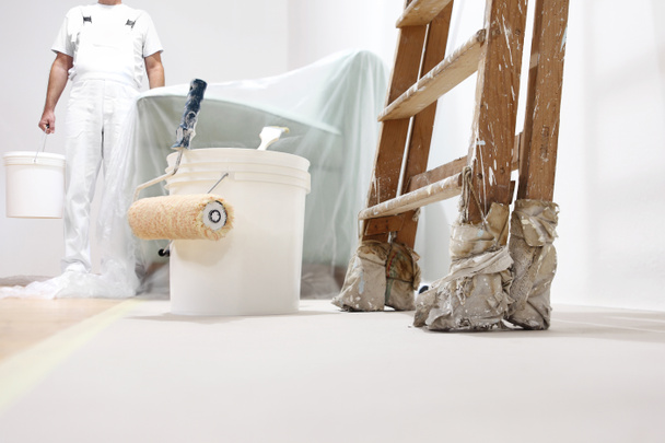 pintor homem no trabalho com um rolo, balde e balança, vista inferior
 - Foto, Imagem