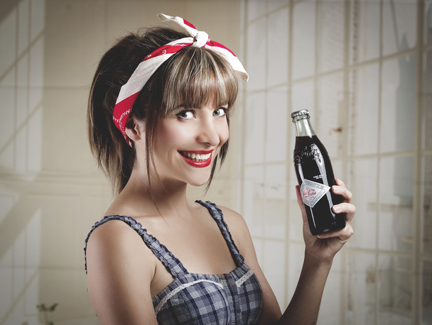 Beautiful retro girl holding an old vintage coca cola bottle - Foto, imagen