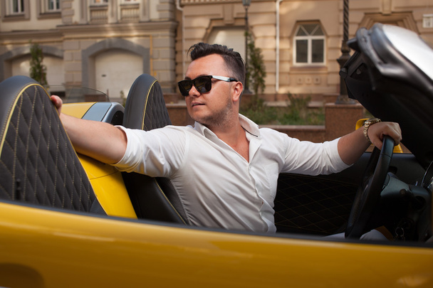 Tyylikäs mies poseeraa avoauton kanssa
 - Valokuva, kuva