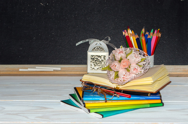 Tanár nap. Virág és ajándék; copybooks a tanári asztalon. - Fotó, kép
