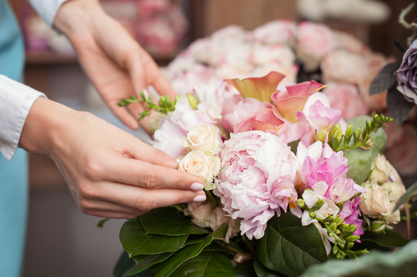 Successful young florist is working in her flower shop - Foto, Bild