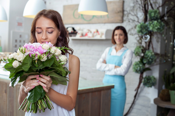 Atractiva joven mujer está comprando flores en la tienda
 - Foto, imagen