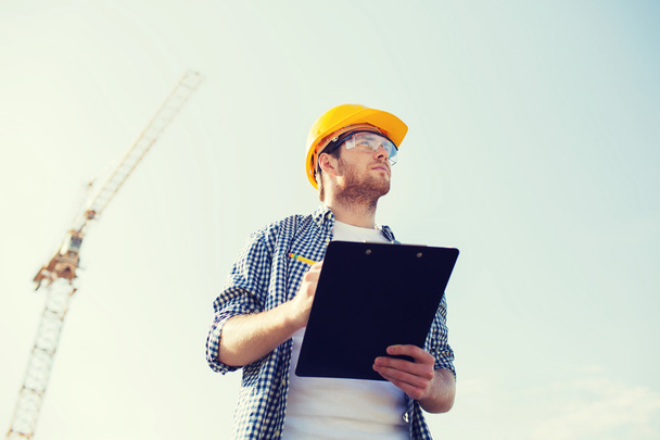 builder in hardhat with clipboard outdoors - Photo, Image