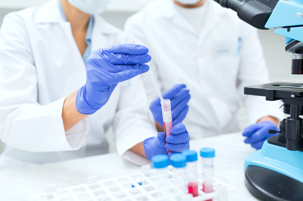 close up of scientists filling test tube in lab - Fotó, kép