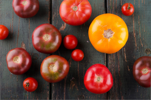 Colorful different kinds of tomatoes on wooden background - Fotografie, Obrázek