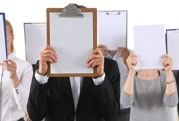 Team of businesspeople holding a folders near face isolated on white background - Φωτογραφία, εικόνα