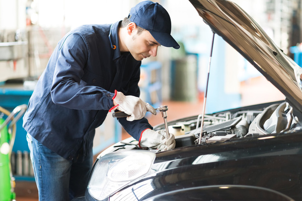 Mechanic repairing a car - Foto, Imagen