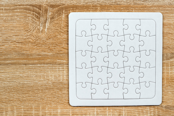 Blank jigsaw puzzle on wooden table - Foto, afbeelding