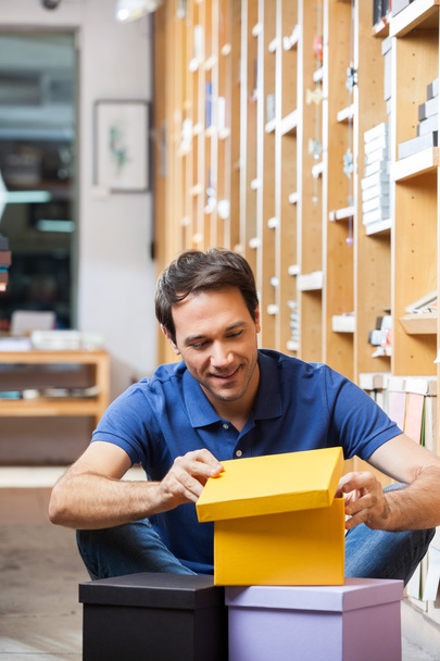Customer Looking At Yellow Cardboard Box In Shop - Foto, immagini