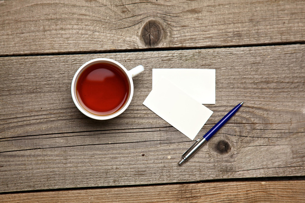 Prázdné vizitky s perem a tea cup na stůl dřevěný úřadu - Fotografie, Obrázek