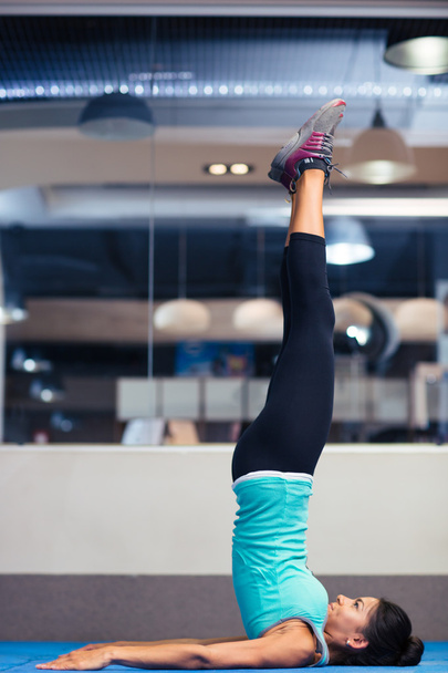 Woman doing yoga exercises in gym - Фото, изображение