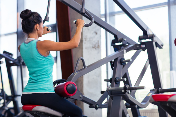 Back view portrait of a woman workout on exercises machine - Valokuva, kuva