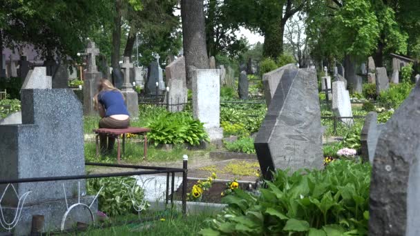 Traurige Frau läuft über den Friedhof. - Filmmaterial, Video