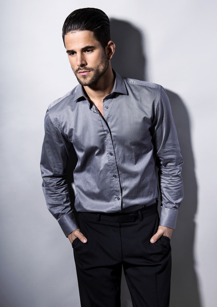 handsome young man in suit on grey background - Fotó, kép