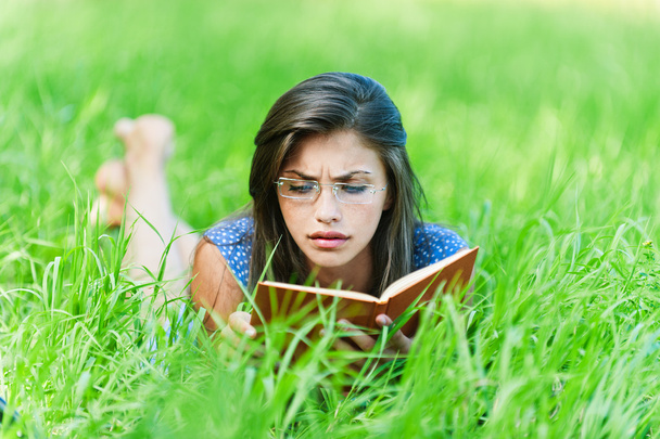 本を読んで横たわっている女性 - 写真・画像