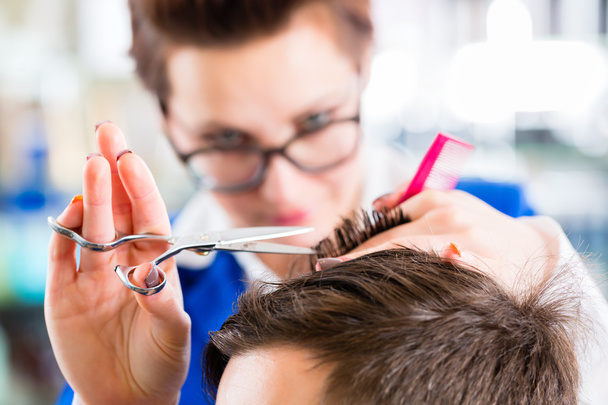 Hairdresser cutting man hair in barbershop - Photo, Image