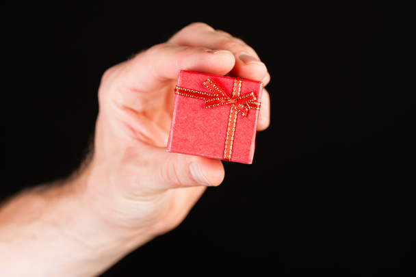 Hand showing red present box  - Foto, afbeelding