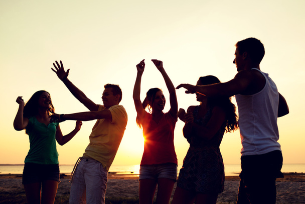 τους φίλους χαμογελώντας χορεύουν στην παραλία το καλοκαίρι - Φωτογραφία, εικόνα