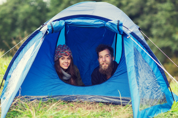 smiling couple of tourists looking out from tent - Fotografie, Obrázek