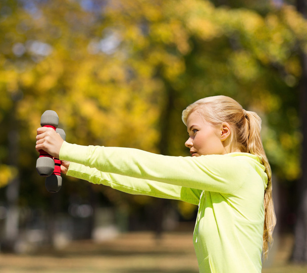 sporty woman with light dumbbells outdoors - Φωτογραφία, εικόνα