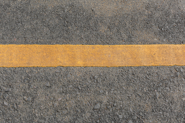 Gele lijn vuil op zwarte asfalt weg textuur - Foto, afbeelding