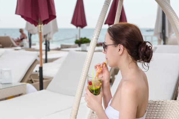 Mujer joven bebiendo bebidas tropicales en el patio del Resort
 - Foto, Imagen
