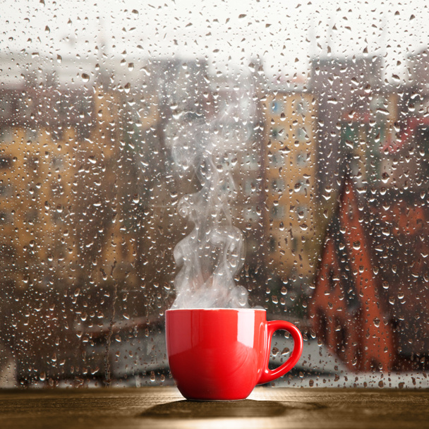 Steaming coffee cup on a rainy day - Photo, Image