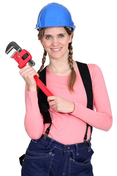 A female construction worker holding a wrench. - Foto, Bild
