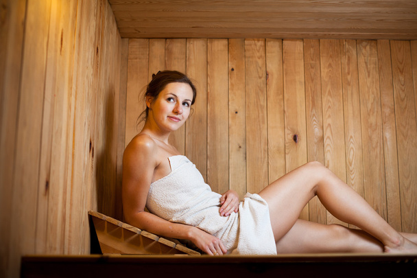 Young woman relaxing in a sauna - Fotoğraf, Görsel
