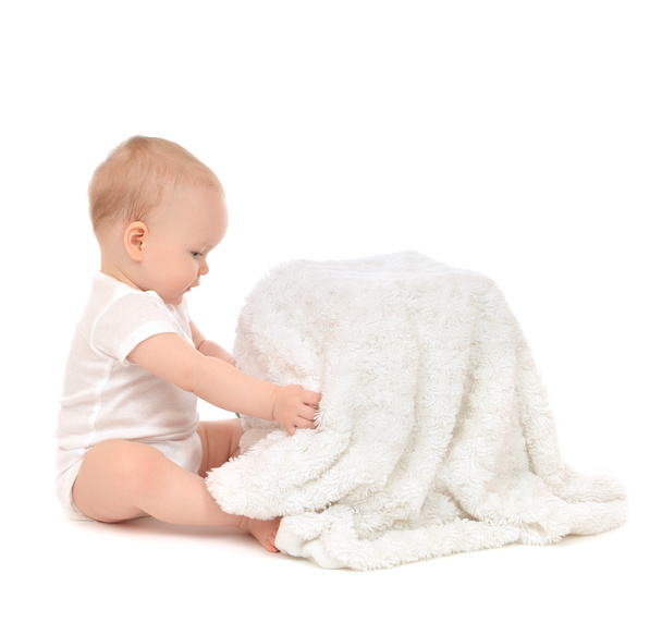 Дитячий малюк сидить і відкриває м'який рушник з ковдрою
 - Фото, зображення