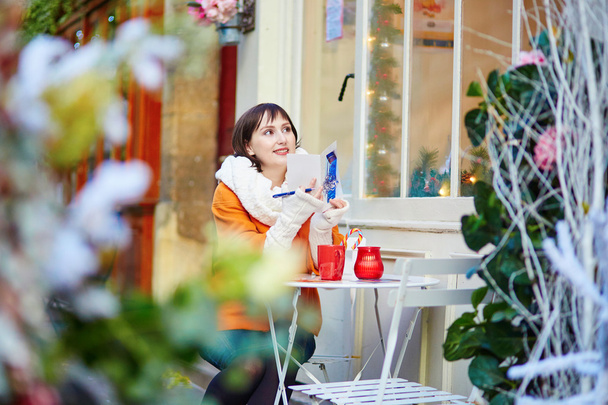 Cheerful young girl in Parisian outdoor cafe - Fotoğraf, Görsel