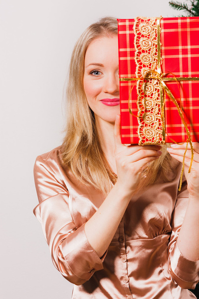 Woman with long blonde hair holding red gift - Photo, image