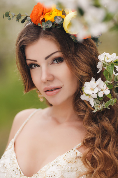 Young beautiful brunette woman in blooming garden - Valokuva, kuva
