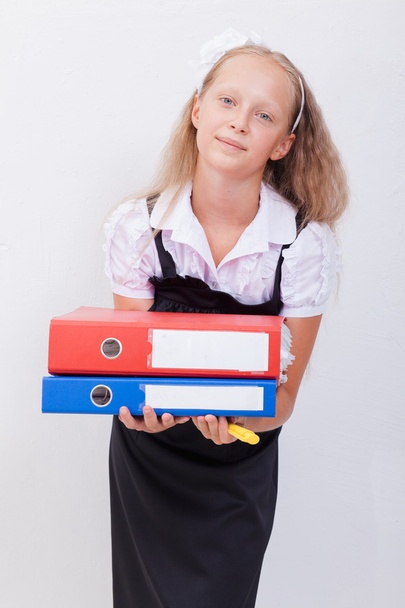 Schoolgirl  holding pen and folders in her hands over white background - Photo, Image