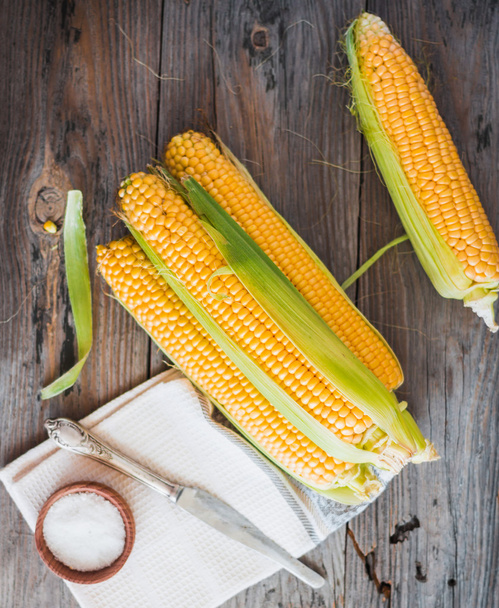 Fresh corn on cobs on a wooden surface, whole plant foods, top v - Fotoğraf, Görsel
