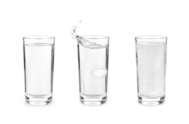 Glass with effervescent tablet in water with bubbles on white ba - Photo, Image