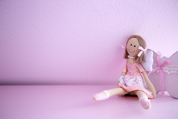 Bambola bambino sulla parete rosa
 - Foto, immagini