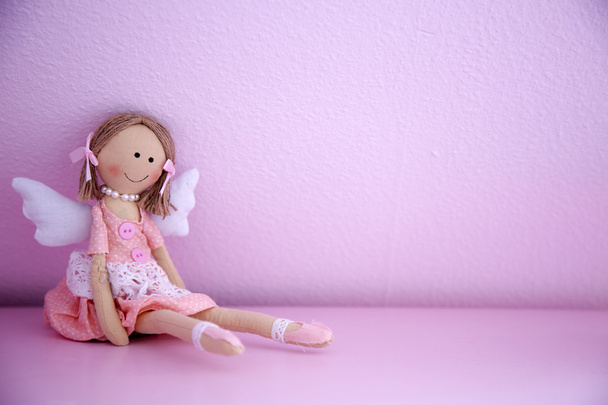 ピンクの壁に赤ちゃん人形 - 写真・画像