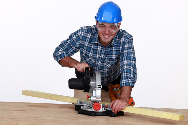 A carpenter with a circular saw. - Фото, зображення