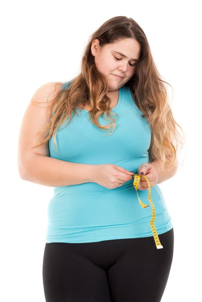 fat girl measuring waist - Foto, afbeelding