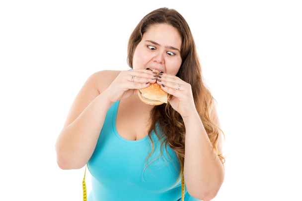 Товста дівчина їсть гамбургер
 - Фото, зображення