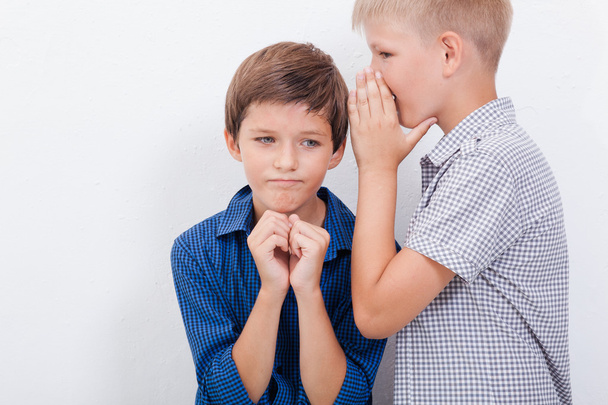 Teenage boy whispering in the ear a secret to friendl on white  background - Foto, Imagem