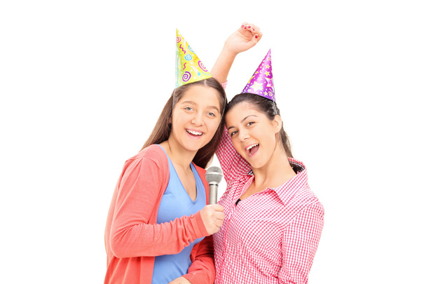 Two teenage girls singing on a microphone - Zdjęcie, obraz