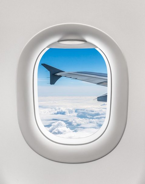 Blick aus dem Fenster eines Flugzeugs auf den Flugzeugflügel und die Wolke - Foto, Bild